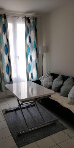 a glass table in a living room with a couch at Modern 1 bedroom apartment near the metro. in Ivry-sur-Seine