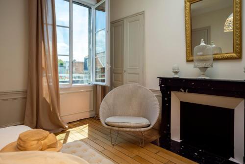 a living room with a chair and a fireplace at La Demeure des Sacres - Cathédrale in Reims