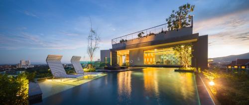 a house with a swimming pool and two chairs at The Astra Chang Khlan Chiang Mai in Chiang Mai