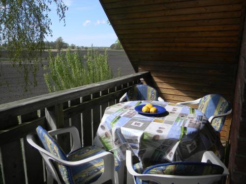 a table with chairs and a bowl of fruit on a porch at Aquamarin in Dahme
