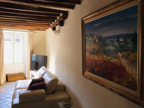 a living room with a couch and a painting on the wall at L'élégante in Saint Paul de Vence