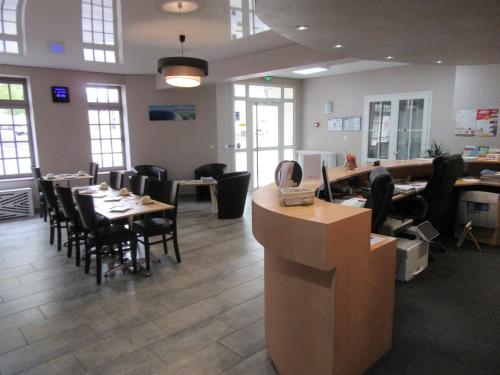 a restaurant with tables and chairs in a room at Contact Hotel de France in Saintes