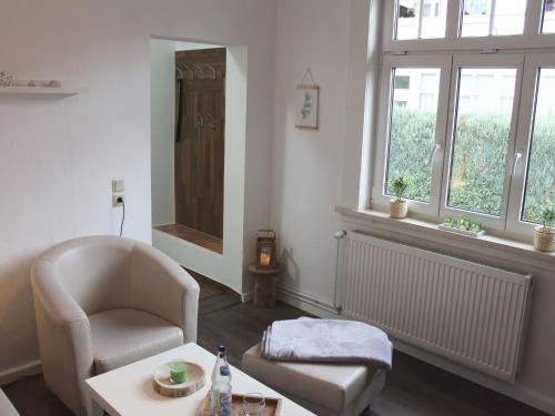 uma sala de estar com uma cadeira, uma mesa e uma janela em Classic holiday home in the Harz Mountains em Ilsenburg