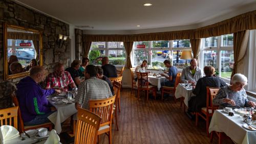 een groep mensen die aan tafel zitten in een restaurant bij Atholl Villa Guest House in Pitlochry