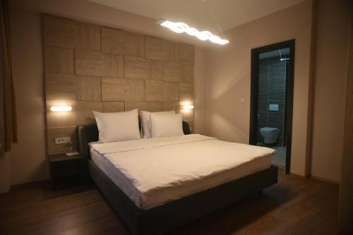 Villa Eleni في إسكوبية: غرفة نوم بسرير كبير عليها شراشف ووسائد بيضاء