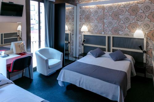 ein Hotelzimmer mit 2 Betten und einem Stuhl in der Unterkunft Hotel Palermo in Barcelona