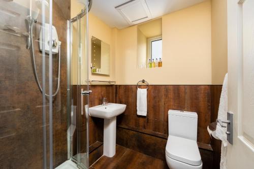 ein Bad mit einem Waschbecken, einem WC und einer Dusche in der Unterkunft The Greenhill Hotel in Wigton