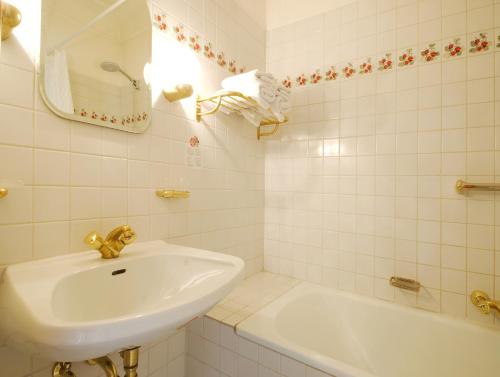 a white bathroom with a sink and a tub at Ristorante Napoleone in Altheim