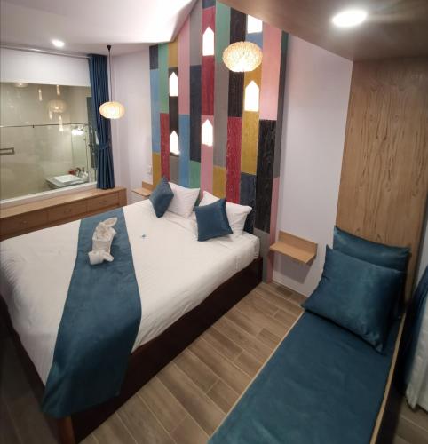 a bedroom with a bed with blue pillows and a mirror at เดอะชาลี The Charlie in Nan