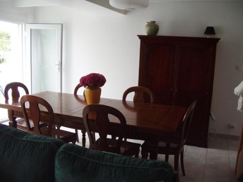 une table de salle à manger avec un vase de fleurs dessus dans l'établissement Gite Hénanbihen, à Hénanbihen