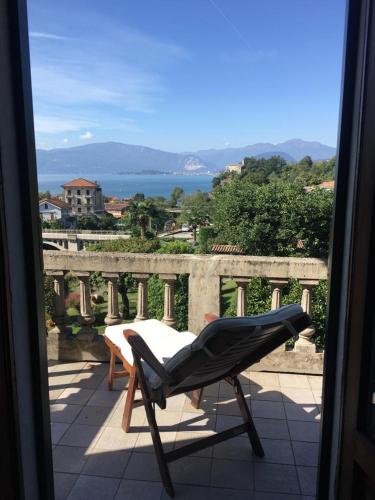 a chair sitting on a balcony looking out a window at il Motto di Tommy in Castelveccana