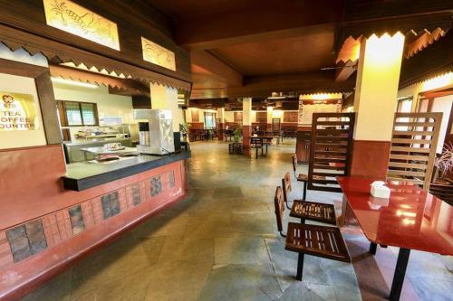 a restaurant with tables and chairs and a counter at Bharat Hotel in Cochin