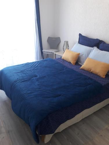 1 cama con edredón azul y almohadas amarillas en Crystal, en Thonon-les-Bains
