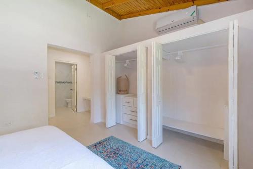a white bedroom with a bed and a closet at New 3-bed on Hip Strip, Beach access, Sleeps 8 in Montego Bay
