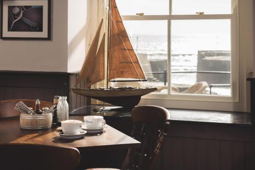 a wooden sail boat on a table in a room at Pier House in St Austell