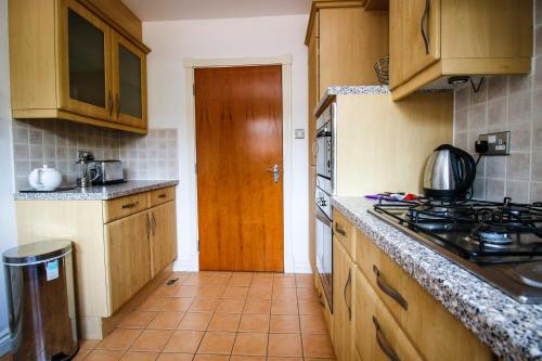 a kitchen with wooden cabinets and a stove top oven at Turnberry Apartments in Turnberry