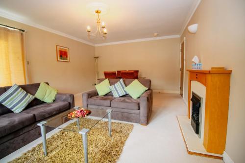 a living room with two couches and a fireplace at Turnberry Apartments in Turnberry
