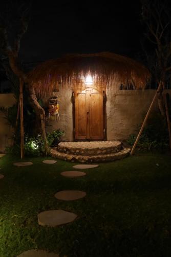 a small hut with a wooden door at night at Amar Boutique Hotel in Canggu