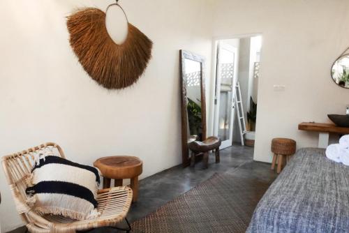 a bedroom with a bed and a mirror at Amar Boutique Hotel in Canggu
