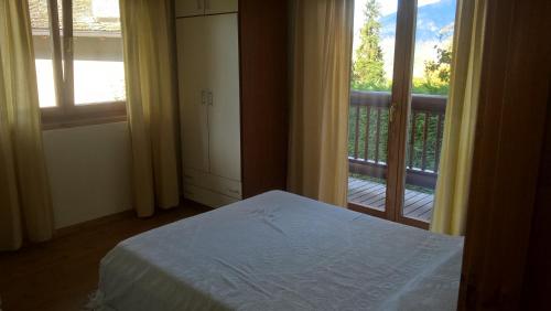 1 Schlafzimmer mit einem Bett und einem Balkon mit einem Fenster in der Unterkunft Casa Moron in Saint Vincent