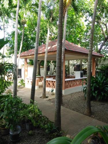 a pavilion in a garden with palm trees at Residencial Estephany in Sosúa