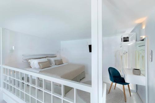 a bedroom with a bed and a desk and a chair at Aether Suite by Caldera Houses in Imerovigli