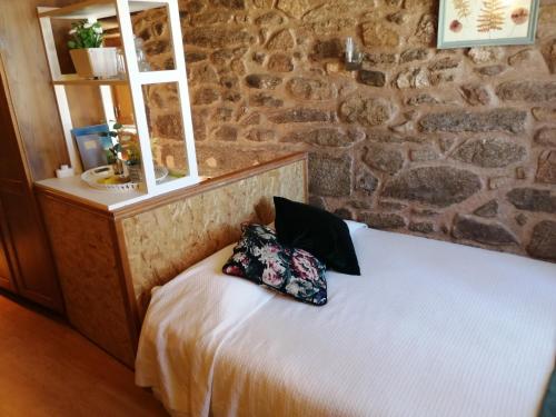 um quarto com uma cama com uma almofada em Casa do Forno em Almeida