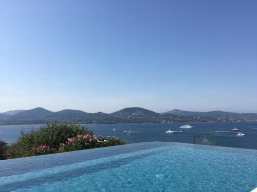 a swimming pool with a view of the water at Les Agathea in Saint-Tropez
