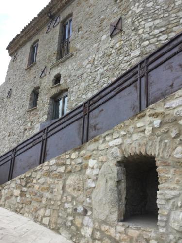 a stone building with a fence on top of it at La Portella in Oppido Lucano