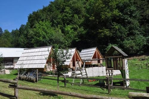 a group of huts in a field next to a fence at Wooden Cabin Kamna Gorica in Kamna Gorica