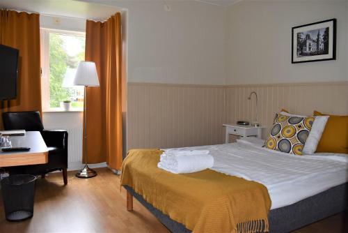 una camera d'albergo con letto, scrivania e finestra di STF Wendelsberg Hotel & Hostel a Mölnlycke