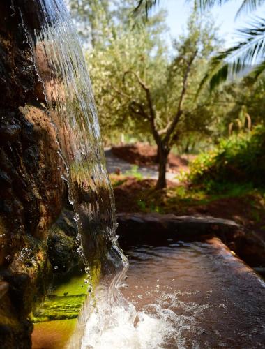 a stream of water coming out of a waterfall at Domaine de la Roseraie Resort in Ouirgane