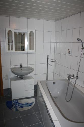 a bathroom with a sink and a bath tub at Monteur-/und Ferienwohnung Diehl in Aßlar