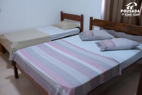 two beds sitting next to each other in a room at Pousada do Gui-Gui Aeroporto in Goiânia