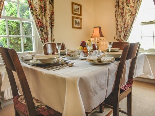 a dining room table with a white table cloth at Charlton Lodge in Mawnan