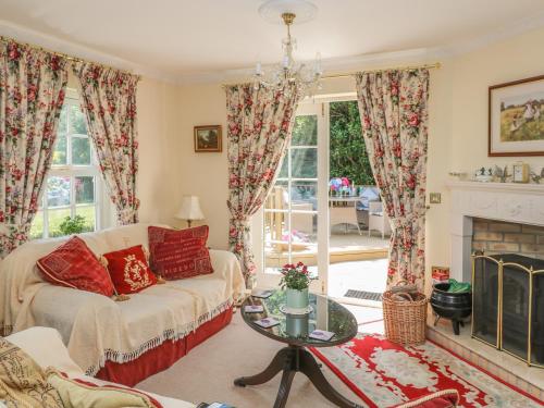 a living room with a couch and a fireplace at Charlton Lodge in Mawnan