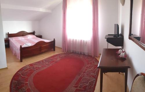 a bedroom with a bed and a red rug at Motel Balcost in Piatra Neamţ