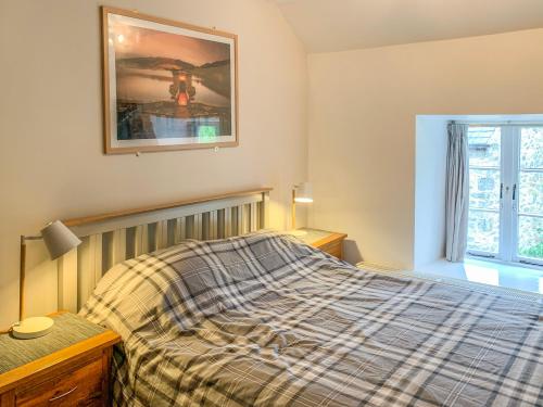 a bedroom with a bed and a picture on the wall at High View Cottage in Castleton