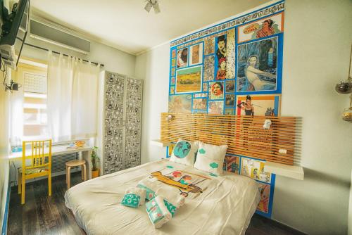 una camera da letto con un letto con immagini appese al muro di Fly B&B a Roma