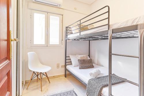- une petite chambre avec des lits superposés et une chaise dans l'établissement LEEWAYS APARTMENT XXIX in GRAN VÍA, à Madrid