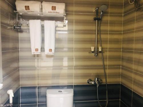 a bathroom with a toilet and towels on the wall at Season Inn Hotel in Barka