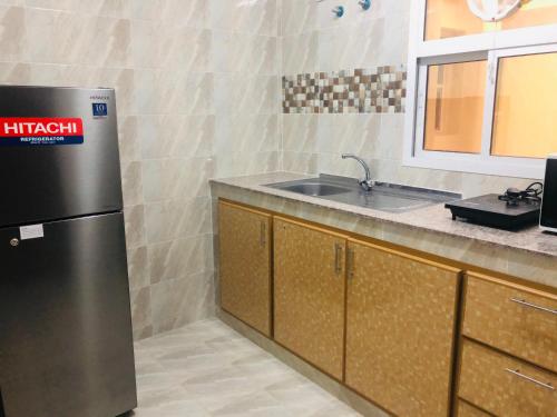 a kitchen with a stainless steel refrigerator and a sink at Season Inn Hotel in Barka