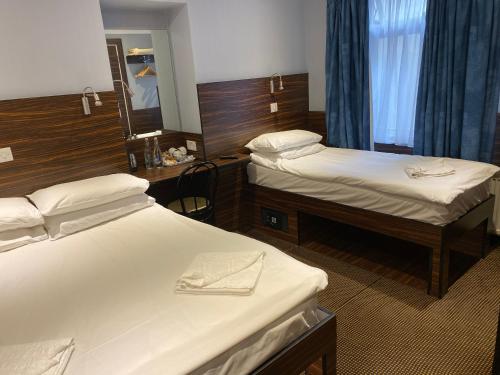 a hotel room with two beds and a mirror at Crestfield Hotel in London