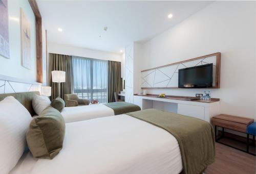a hotel room with two beds and a tv at ISG Sabiha Gökçen Airport Hotel in Istanbul