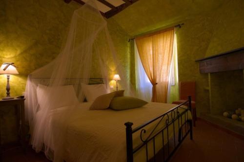 una camera da letto con un letto con lenzuola bianche e una finestra di Locanda Guelfo a Tredozio