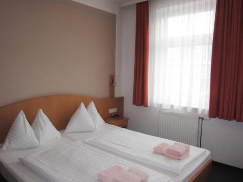 a bedroom with a bed with two pink towels on it at Pension Elisabeth in Sankt Pölten