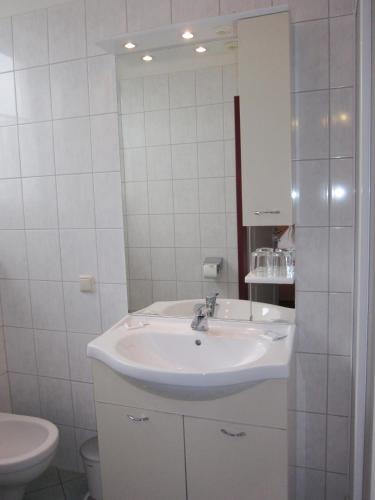 a white bathroom with a sink and a toilet at Pension Elisabeth in Sankt Pölten