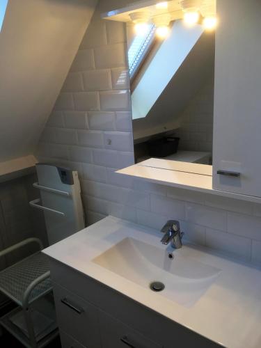 une salle de bain avec un lavabo et un miroir dans l'établissement Iroise Duplex T3, à Le Touquet-Paris-Plage