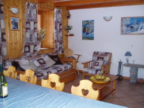 un salon avec un canapé et une table dans l'établissement Chalet les Gentianes, à Les Coches