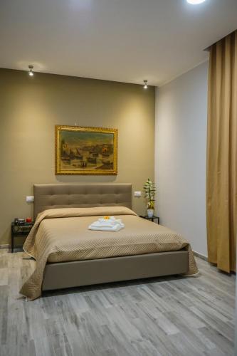 a bedroom with a bed with a painting on the wall at B&B Le Canapine in Frattamaggiore